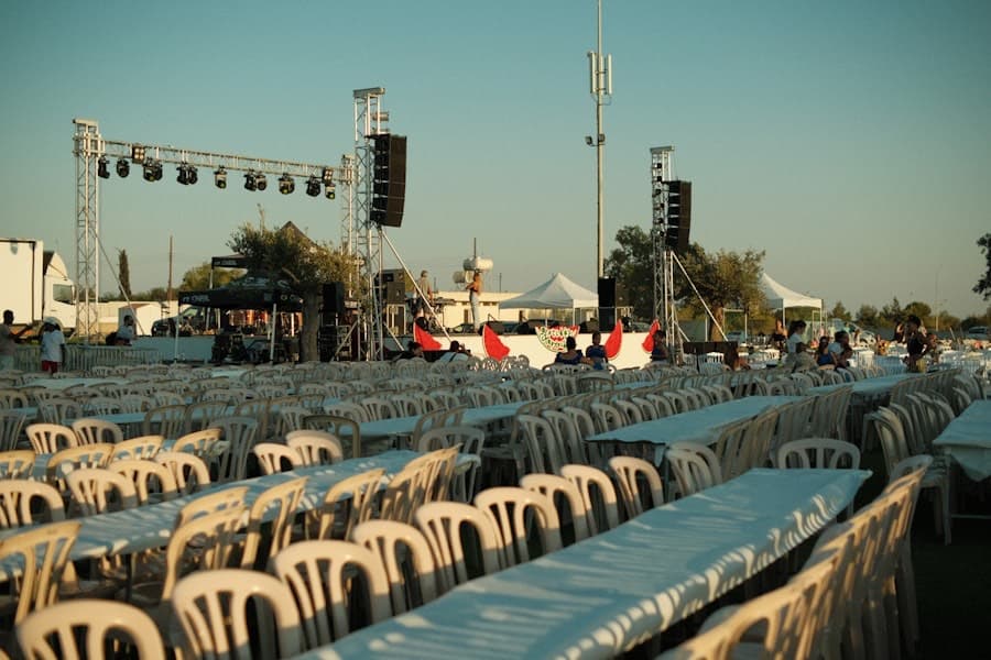 Rows of chairs and a stage being set up for an outdoor public event